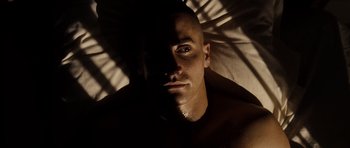 Movie still from “Jarhead” (2005), directed by Sam Mendes – A person laying in a bed; Close Up shot, High angle