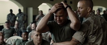 Movie still from “Jarhead” (2005), directed by Sam Mendes – A man with his head in his hands is crying; Close Up shot, Over the shoulder angle