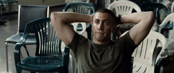 Movie still from “Jarhead” (2005), directed by Sam Mendes – A man sitting on a chair with his hands behind his head; Close Up shot, Over the shoulder angle