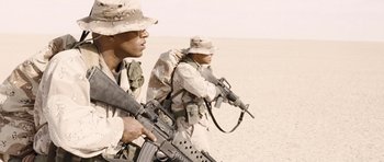 Movie still from “Jarhead” (2005), directed by Sam Mendes – Two men in camouflage uniforms are walking through the desert; Medium shot, Low angle