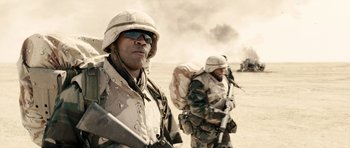 Movie still from “Jarhead” (2005), directed by Sam Mendes – Two men in military uniforms are standing in the desert; Medium shot, Over the shoulder angle