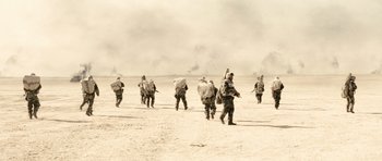 Movie still from “Jarhead” (2005), directed by Sam Mendes – A black and white photo of a group of soldiers walking across a field; Extreme Wide shot, High angle