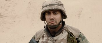 Movie still from “Jarhead” (2005), directed by Sam Mendes – A man in a military uniform is looking at the camera; Close Up shot, Low angle
