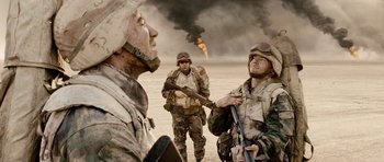 Movie still from “Jarhead” (2005), directed by Sam Mendes – A group of men standing next to each other in the desert; Medium shot, Over the shoulder angle