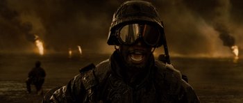 Movie still from “Jarhead” (2005), directed by Sam Mendes – A man in a helmet and goggles is smiling for the camera; Close Up shot, High angle