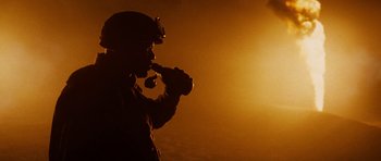 Movie still from “Jarhead” (2005), directed by Sam Mendes – A man with a pipe in his mouth is standing in front of the sun; Close Up shot, Low angle