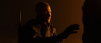 Movie still from “Jarhead” (2005), directed by Sam Mendes – A man in a black jacket is holding something in his hand; Close Up shot, Over the shoulder angle