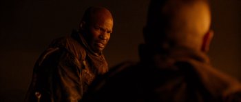 Movie still from “Jarhead” (2005), directed by Sam Mendes – A man with a bald head is looking at the camera; Close Up shot, Over the shoulder angle