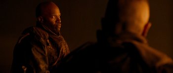 Movie still from “Jarhead” (2005), directed by Sam Mendes – A man in a brown jacket is looking at the camera; Close Up shot, Over the shoulder angle