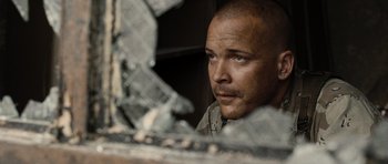 Movie still from “Jarhead” (2005), directed by Sam Mendes – A man looking into a shattered window; Close Up shot, Over the shoulder angle