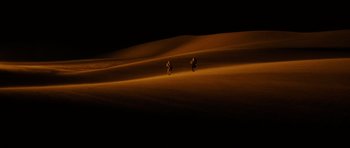 Movie still from “Jarhead” (2005), directed by Sam Mendes – A couple of people riding bikes in the dark; Extreme Wide shot, High angle