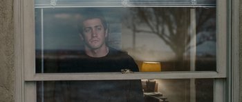 Movie still from “Jarhead” (2005), directed by Sam Mendes – A man looking out of a window at night; Medium shot, Low angle