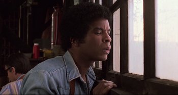 Movie still from “Jumanji” (1995), directed by Joe Johnston – A man looking out of a window at the sun; Close Up shot, Low angle