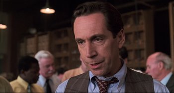 Movie still from “Jumanji” (1995), directed by Joe Johnston – A person wearing a vest and a tie; Close Up shot, Over the shoulder angle