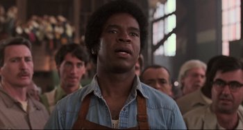 Movie still from “Jumanji” (1995), directed by Joe Johnston – A man in a blue shirt and brown apron looking up; Close Up shot, Low angle