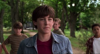 Movie still from “Jumanji” (1995), directed by Joe Johnston – A boy in a jean jacket and a boy in a brown shirt; Close Up shot, Over the shoulder angle