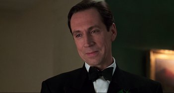 Movie still from “Jumanji” (1995), directed by Joe Johnston – A person wearing a suit and bow tie; Close Up shot, Low angle