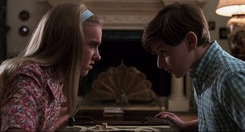Movie still from “Jumanji” (1995), directed by Joe Johnston – Two young people looking at each other in front of a fireplace; Close Up shot, Over the shoulder angle