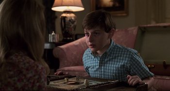 Movie still from “Jumanji” (1995), directed by Joe Johnston – A young boy sitting in front of a woman playing a board game; Close Up shot, Over the shoulder angle