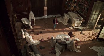 Movie still from “Jumanji” (1995), directed by Joe Johnston – A room filled with lots of debris and pieces of furniture; Wide shot, High angle