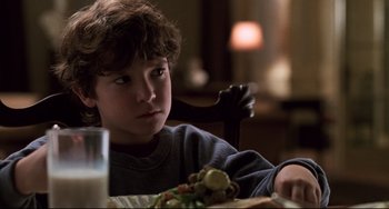 Movie still from “Jumanji” (1995), directed by Joe Johnston – A boy sitting at a table with a sandwich in front of him; Close Up shot, High angle