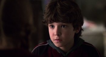 Movie still from “Jumanji” (1995), directed by Joe Johnston – A young boy is looking into the distance; Close Up shot, Over the shoulder angle