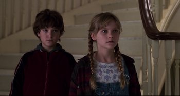 Movie still from “Jumanji” (1995), directed by Joe Johnston – Two young children standing next to each other; Close Up shot, Low angle