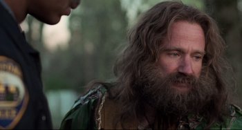 Movie still from “Jumanji” (1995), directed by Joe Johnston – A man with long hair and a long beard; Close Up shot, Over the shoulder angle
