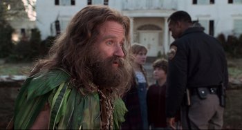 Movie still from “Jumanji” (1995), directed by Joe Johnston – A man with long hair and a long beard; Close Up shot, Over the shoulder angle