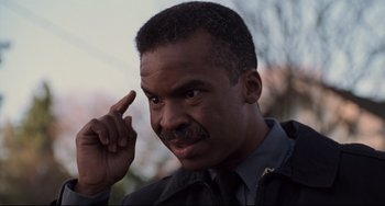 Movie still from “Jumanji” (1995), directed by Joe Johnston – A person holding his hand up to his head; Close Up shot, High angle