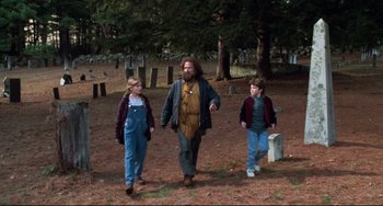 Movie still from “Jumanji” (1995), directed by Joe Johnston – A man and two young children walking in a field; Wide shot, Over the shoulder angle