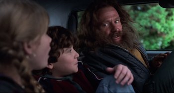 Movie still from “Jumanji” (1995), directed by Joe Johnston – A group of people sitting in the back of a car; Medium shot, Over the shoulder angle