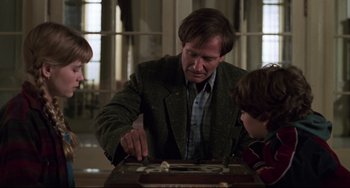 Movie still from “Jumanji” (1995), directed by Joe Johnston – A man and a boy are playing a game of backgammon; Medium shot, Over the shoulder angle