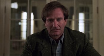 Movie still from “Jumanji” (1995), directed by Joe Johnston – A person wearing a suit and tie; Close Up shot, Over the shoulder angle