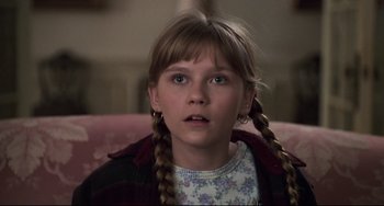 Movie still from “Jumanji” (1995), directed by Joe Johnston – A young girl with long braids sitting on a pink couch; Close Up shot, High angle