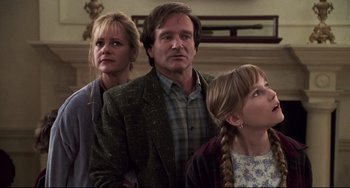 Movie still from “Jumanji” (1995), directed by Joe Johnston – Two women and a man standing next to each other; Medium shot, Low angle