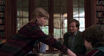 Movie still from “Jumanji” (1995), directed by Joe Johnston – A man and a woman standing next to each other in a room; Medium shot, Over the shoulder angle