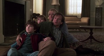 Movie still from “Jumanji” (1995), directed by Joe Johnston – A group of people sitting in a living room together; Medium shot, High angle