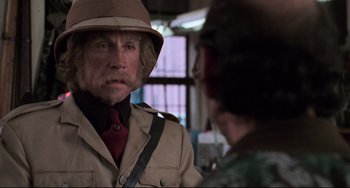 Movie still from “Jumanji” (1995), directed by Joe Johnston – A man wearing a hat and a jacket; Close Up shot, Over the shoulder angle