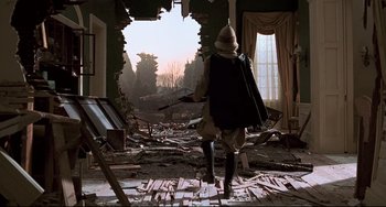 Movie still from “Jumanji” (1995), directed by Joe Johnston – A man is walking through the ruins of a house; Wide shot, Low angle
