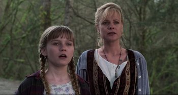 Movie still from “Jumanji” (1995), directed by Joe Johnston – A woman standing next to a young girl in front of a forest; Close Up shot, Low angle