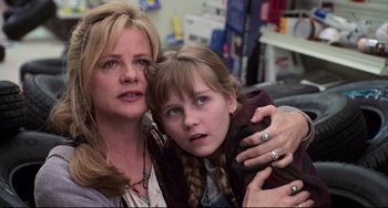 Movie still from “Jumanji” (1995), directed by Joe Johnston – A woman and a young girl pose for a picture; Close Up shot, Low angle