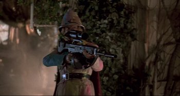 Movie still from “Jumanji” (1995), directed by Joe Johnston – A person in a costume holding a rifle; Medium shot, Low angle