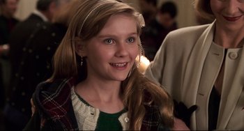 Movie still from “Jumanji” (1995), directed by Joe Johnston – A young girl with long blonde hair wearing a green sweater; Close Up shot, Over the shoulder angle
