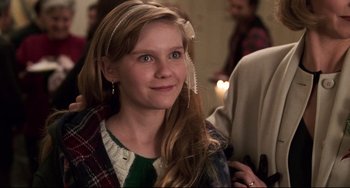 Movie still from “Jumanji” (1995), directed by Joe Johnston – A young girl with long blonde hair wearing a green sweater; Close Up shot, Over the shoulder angle