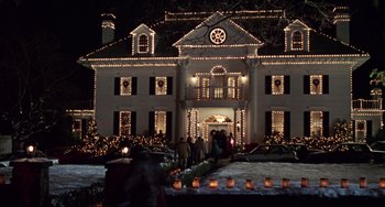 Movie still from “Jumanji” (1995), directed by Joe Johnston – A group of people standing in front of a large house; Extreme Wide shot, Low angle