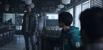 Movie still from “Black Summer” (2019), created by John Hyams – A group of people standing in a room; Medium shot, Over the shoulder angle