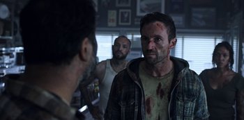 Movie still from “Black Summer” (2019), created by John Hyams – A group of men standing next to each other in a room; Medium shot, Over the shoulder angle