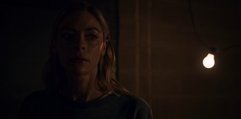 Movie still from “Black Summer” (2019), created by John Hyams – A woman is standing in a dark room; Close Up shot, Low angle