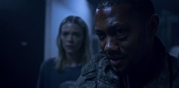 Movie still from “Black Summer” (2019), created by John Hyams – A man and a woman are standing in a hallway; Close Up shot, Over the shoulder angle